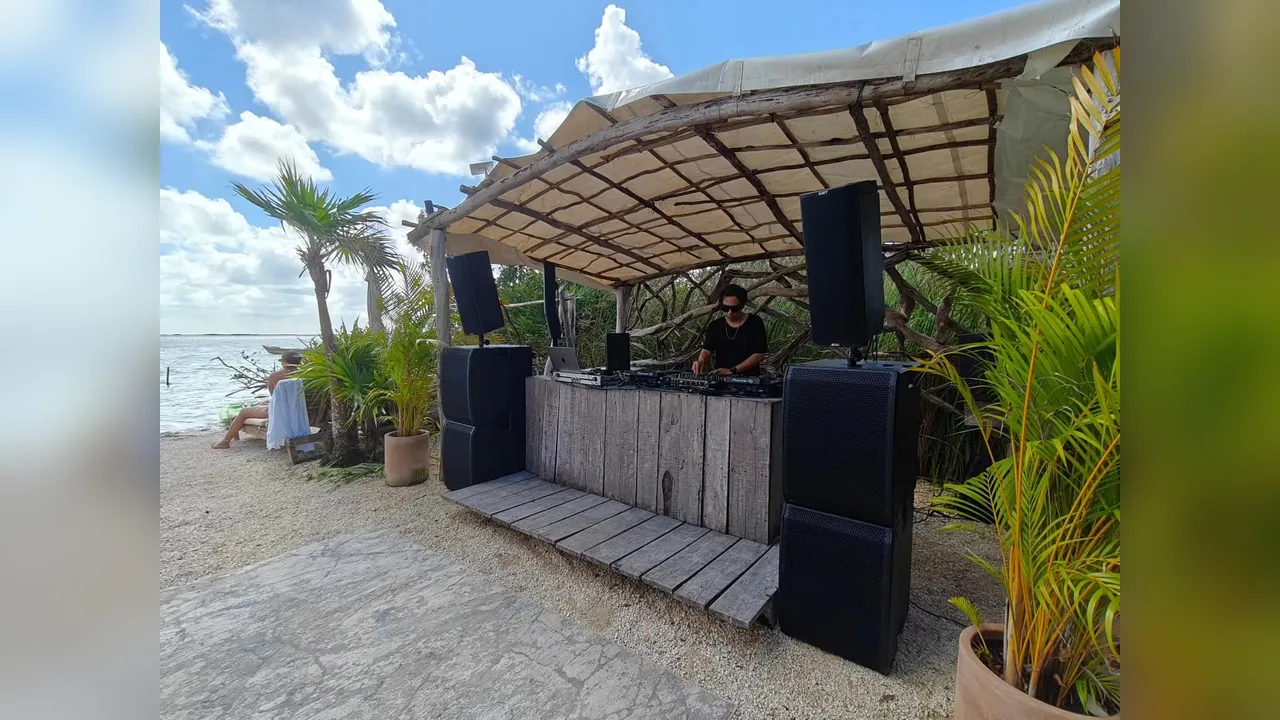 DJ booth and sound system set up by the water in Tulum